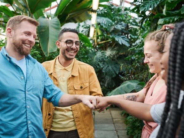 Four people bumping their fists together